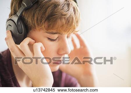 Teenage boy (14-15) wearing headphones View Large Photo Image Stock Photography - Teenage boy (14-15) wearing headphones. Fotosearch
