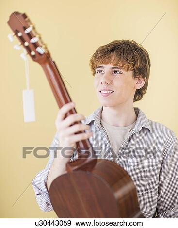 Teenage boy (14-15) with guitar View Large Photo Image Stock Photo - Teenage boy (14-15) with guitar. Fotosearch