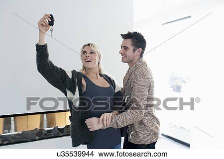 Picture - Woman holding car keys while man embracing her. Fotosearch