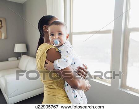 Stock Photo - Woman holding her son (2-5 months). Fotosearch