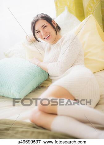 Woman leaning against pillow, Looking at camera, Smiling View Large Photo Image Stock Photo - Woman leaning against pillow, Looking at camera, Smiling. Fotosearch