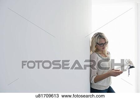 Woman reading book indoors View Large Photo Image Stock Image - Woman reading book indoors. Fotosearch