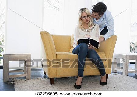 Woman reading book while man kissing her View Large Photo Image Stock Photography - Woman reading book while man kissing her. Fotosearch