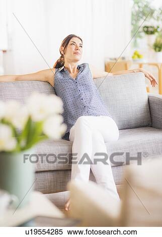 Stock Photography - Woman relaxing on sofa. Fotosearch