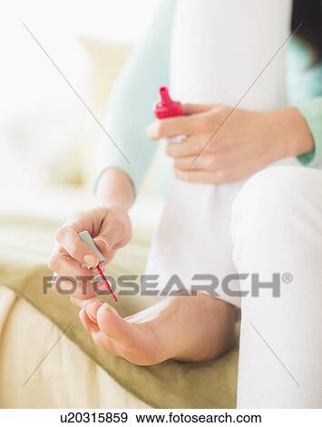 Woman sitting on bed and polishing toe nails View Large Photo Image Stock Photo - Woman sitting on bed and polishing toe nails. Fotosearch