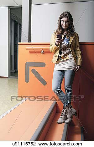 Woman standing on steps and text messaging View Large Photo Image Stock Image - Woman standing on steps and text messaging. Fotosearch