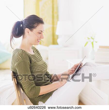 Stock Photograph - Woman using tablet pc. Fotosearch