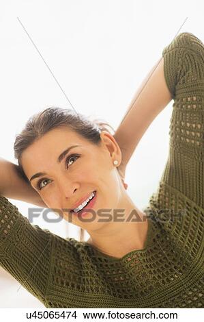 Picture - Woman with hands behind head. Fotosearch