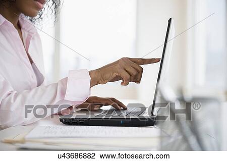 Stock Image - Woman working on laptop. Fotosearch