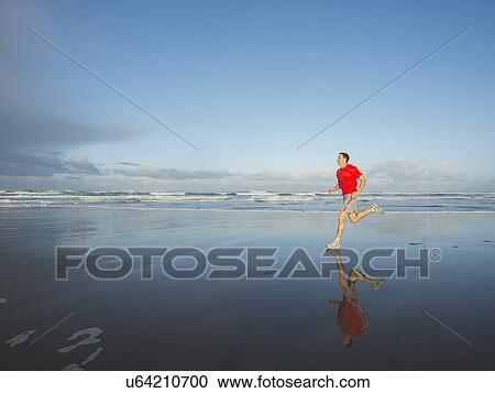 Young adult man running on beach View Large Photo Image Stock Image - Young adult man running on beach. Fotosearch