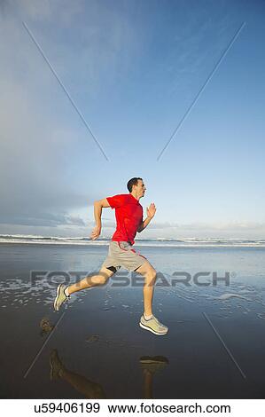 Young adult man running on beach View Large Photo Image Stock Photo - Young adult man running on beach. Fotosearch