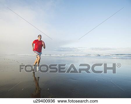 Young adult man running on beach View Large Photo Image Stock Photograph - Young adult man running on beach. Fotosearch