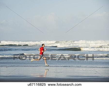 Stock Photography - Young adult man running on beach. Fotosearch