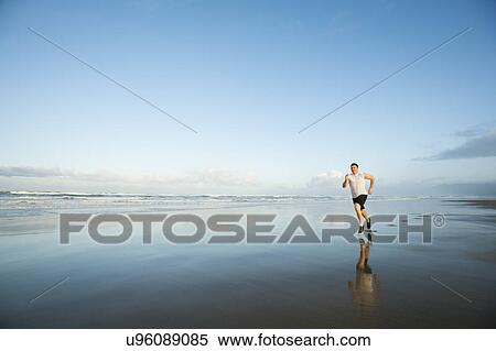 Young adult man running on beach View Large Photo Image Stock Photography - Young adult man running on beach. Fotosearch