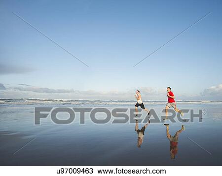 Young adult men running on beach View Large Photo Image Stock Image - Young adult men running on beach. Fotosearch