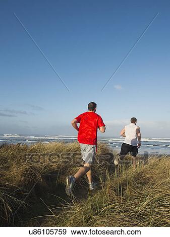 Young adult men running on dune View Large Photo Image Stock Photo - Young adult men running on dune. Fotosearch