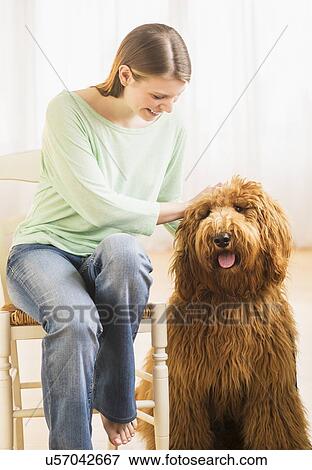 Stock Photo - Young cheerful woman with her dog. Fotosearch