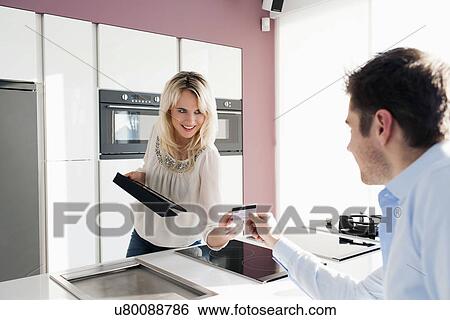 Stock Photograph - Young couple in kitchen. Fotosearch