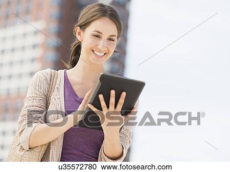 Young female using digital tablet View Large Photo Image Stock Image - Young female using digital tablet. Fotosearch