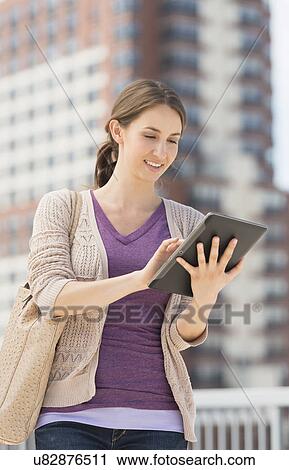 Young female using digital tablet View Large Photo Image Stock Image - Young female using digital tablet. Fotosearch