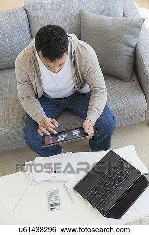 Young man doing home finances View Large Photo Image Stock Photograph - Young man doing home finances. Fotosearch