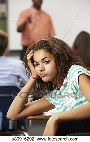 Stock Image - Bored Female Teenage Pupil In Classroom. Fotosearch