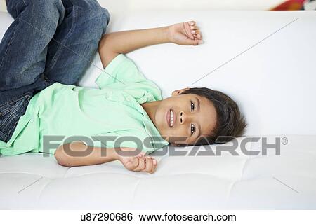 Stock Photograph - Boy Playing On Sofa. Fotosearch