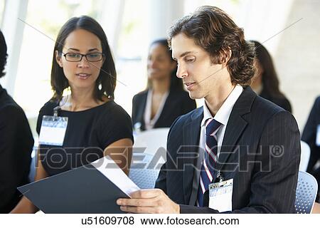 Stock Photo - Businessman Discussing Conference Document With Colleague. Fotosearch