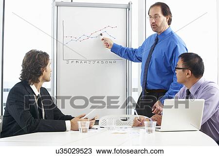 Businessman Giving Presentation To Colleagues View Large Photo Image Stock Image - Businessman Giving Presentation To Colleagues. Fotosearch