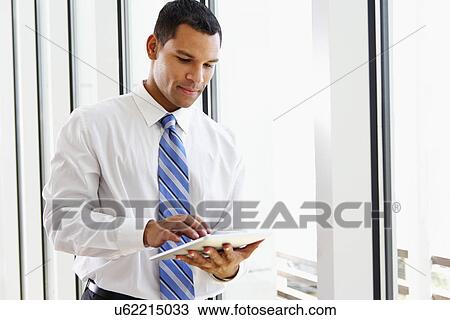 Businessman Using Digital Tablet In Office View Large Photo Image Stock Image - Businessman Using Digital Tablet In Office. Fotosearch