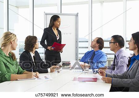 Stock Image - Businesswoman Conducting Meeting In Boardroom. Fotosearch