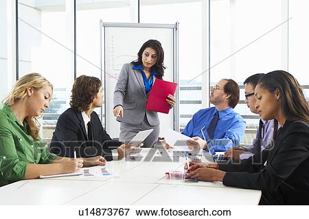 Stock Photo - Businesswoman Conducting Meeting In Boardroom. Fotosearch