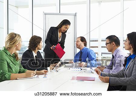 Stock Photo - Businesswoman Conducting Meeting In Boardroom. Fotosearch