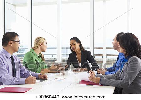 Stock Photo - Businesswoman Conducting Meeting In Boardroom. Fotosearch