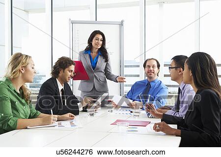 Stock Photograph - Businesswoman Conducting Meeting In Boardroom. Fotosearch