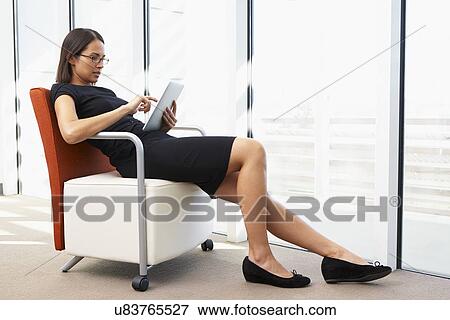 Businesswoman Relaxing With Digital Tablet During Break View Large Photo Image Stock Photo - Businesswoman Relaxing With Digital Tablet During Break. Fotosearch