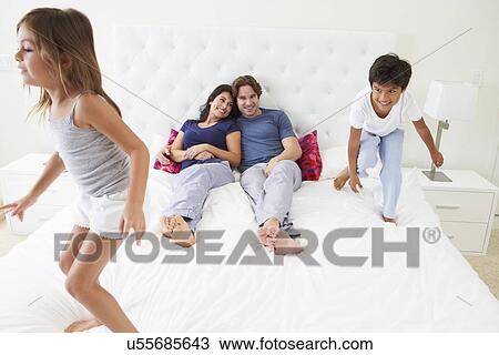 Children Jumping On Parents Bed Wearing Pajamas View Large Photo Image Stock Image - Children Jumping On Parents Bed Wearing Pajamas. Fotosearch