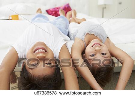 Children Lying Upside Down On Bed In Pajamas Together View Large Photo Image Stock Photo - Children Lying Upside Down On Bed In Pajamas Together. Fotosearch