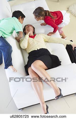 Stock Photography - Children Welcoming Tired Mother Returning From Work. Fotosearch