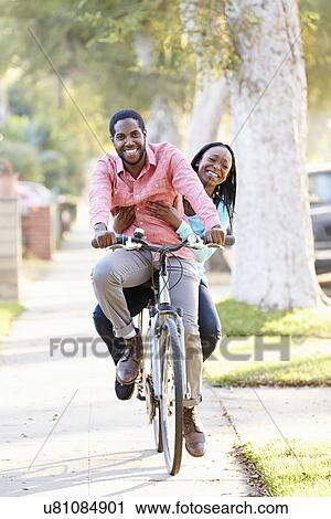 Couple Cycling Along Suburban Street Together View Large Photo Image Stock Image - Couple Cycling Along Suburban Street Together. Fotosearch