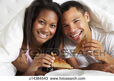 Stock Image - Couple Enjoying Breakfast In Bed. Fotosearch