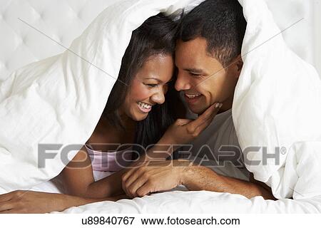 Couple Relaxing In Bed Hiding Under Duvet View Large Photo Image Stock Photo - Couple Relaxing In Bed Hiding Under Duvet. Fotosearch