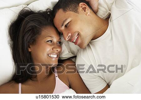 Couple Relaxing In Bed Wearing Pajamas View Large Photo Image Stock Image - Couple Relaxing In Bed Wearing Pajamas. Fotosearch