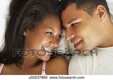 Couple Relaxing In Bed Wearing Pajamas View Large Photo Image Stock Image - Couple Relaxing In Bed Wearing Pajamas. Fotosearch