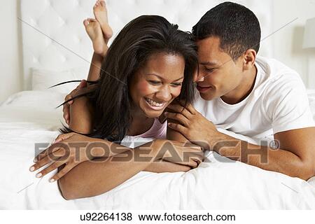 Stock Photo - Couple Relaxing In Bed Wearing Pajamas. Fotosearch