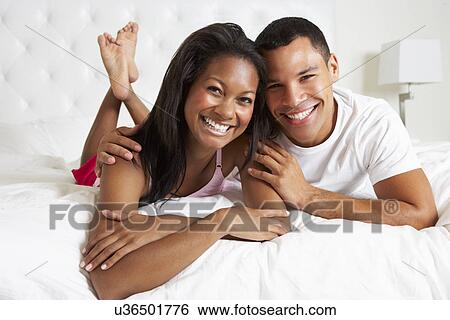 Couple Relaxing In Bed Wearing Pajamas View Large Photo Image Stock Photograph - Couple Relaxing In Bed Wearing Pajamas. Fotosearch