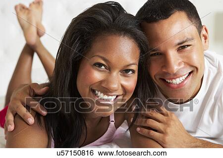 Stock Photograph - Couple Relaxing In Bed Wearing Pajamas. Fotosearch