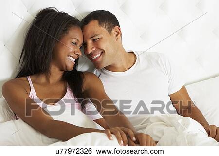 Couple Relaxing In Bed Wearing Pajamas View Large Photo Image Stock Photograph - Couple Relaxing In Bed Wearing Pajamas. Fotosearch