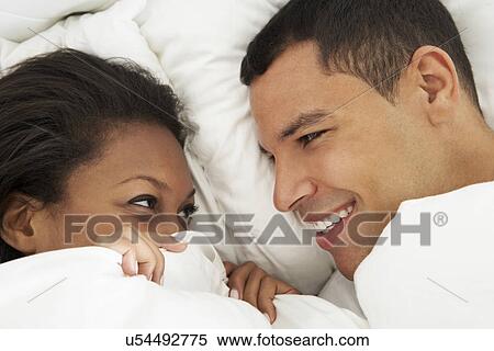 Stock Photography - Couple Relaxing In Bed Wearing Pajamas. Fotosearch