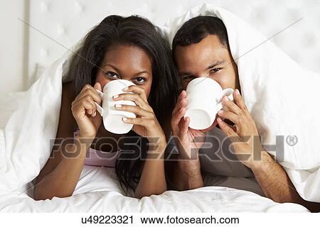 Couple Relaxing In Bed With Hot Drink View Large Photo Image Stock Image - Couple Relaxing In Bed With Hot Drink. Fotosearch